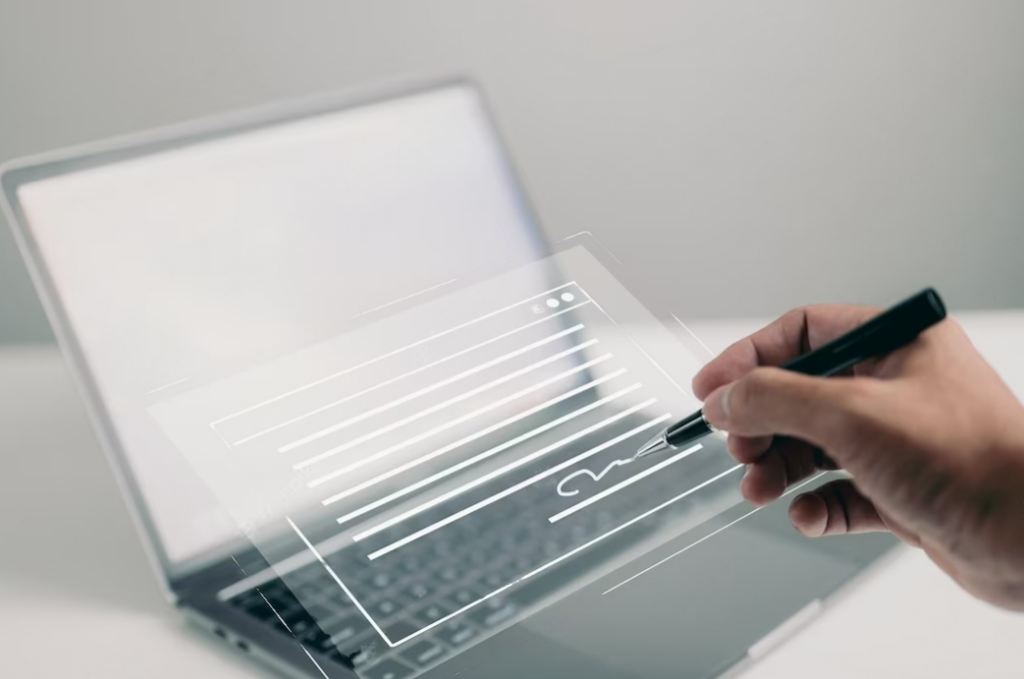 hand writing with a pan on transparent digital notes, opened laptop behind